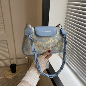 Hellblaue Achseltasche mit goldenem Blumenmuster und dekorativer Kette