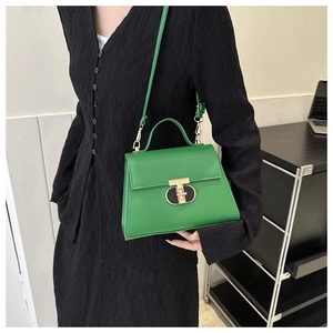 Detail of a bright green PU leather handbag featuring a gold T-shaped twist lock closure