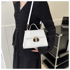 Close-up of white synthetic leather handbag featuring golden T-shaped metal buckle detail