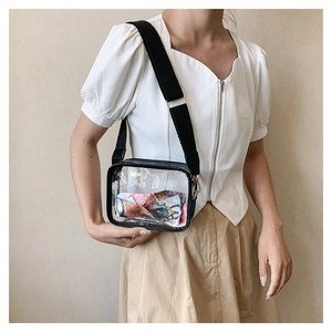 Detailed close-up of transparent PVC crossbody bag with wide strap and floral scarf decor