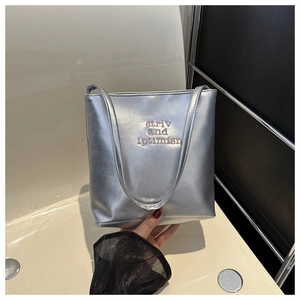 Detail of silver metallic PU leather tote bag featuring striv and iptimisn embroidery