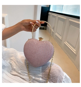 Pink sequin heart-shaped evening bag featuring a gold metal round handle and chain strap