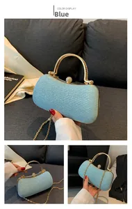 Close-up of light blue sequined evening clutch with gold handle and crystal clasp detail