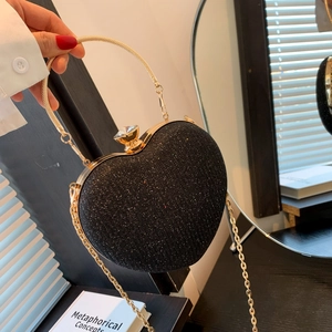 Elegant heart-shaped black glitter clutch bag with gold handle and crystal clasp