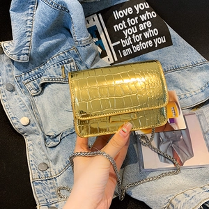Glossy gold crocodile pattern mini square bag with silver chain strap on denim back