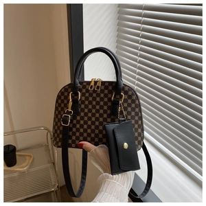 Close-up of vintage shell-shaped handbag with yellow geometric pattern and gold zipper detail
