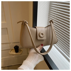 Detail of apricot moon bag with knot strap and round magnetic clasp in a modern setting