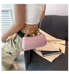 Close-up of pink sequined evening clutch with gold metal handle and beaded clasp detail