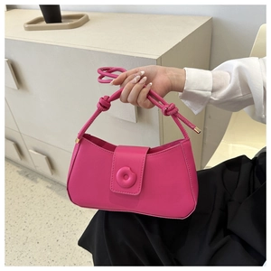 Modern rose pink crescent bag with knotted strap and gold circular hardware detail
