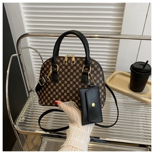 Detail of dome shell bag showing brown monogram pattern and mini pouch with gold hardware