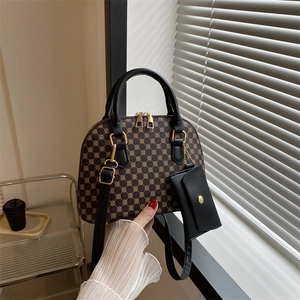 Classic dark brown monogram shell bag with black top handles and a mini coin purse charm