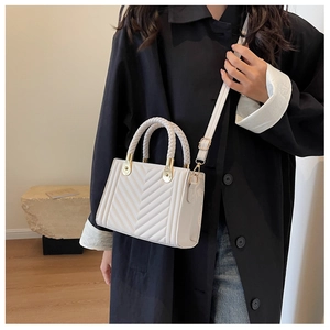 Fashionable cream white crossbody bag with V-shaped quilting and woven handle on model