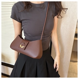 Detailed view of brown PU leather shoulder bag with crescent shape and gold buckle accent