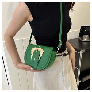 Detail of green saddle bag showing vintage gold buckle and smooth leather texture