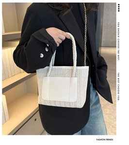 Détail du sac seau en paille avec poche en cuir blanc et poignée en corde épaisse