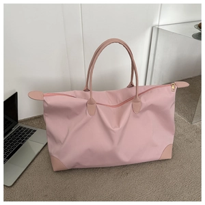 Detail der pinkfarbenen Reisetasche aus Nylon mit Ledergriffen und verstärkten Ecken