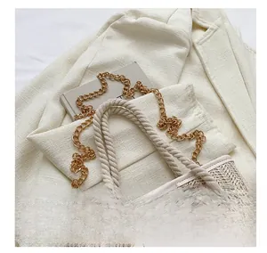 Détail du sac cabas beige tissé avec poignées en corde et chaînes dorées élégantes