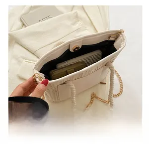 Détail de l'intérieur du sac en paille tissée montrant la capacité pour téléphone