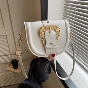 White saddle shoulder bag with decorative gold baroque buckle and slim strap