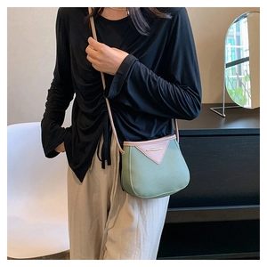 Détail du sac bandoulière vert avocat en cuir avec rabat triangulaire de couleur rose
