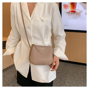 Détail du sac à bandoulière en cuir grainé kaki avec rabat en V et barre métallique dorée