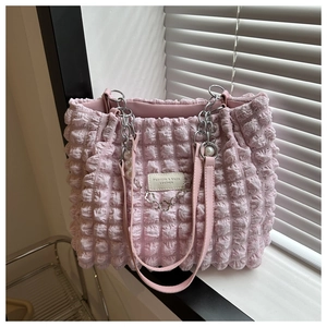 Detail of pink bubble texture tote bag with pearl pendant and metal chain handles