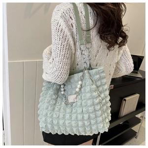 Vue détaillée du sac cabas vert menthe à texture bulle avec breloque en perle