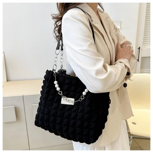 Détail du sac cabas matelassé noir avec chaîne fleurie perlée et bandoulière en cuir