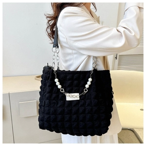 Détail du sac noir texturé à bulles avec chaîne argentée et bandoulière en perles élégantes