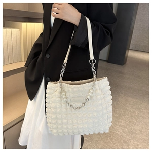 Sac fourre-tout blanc texturé avec chaîne en perles et fleurs porté par le mannequin
