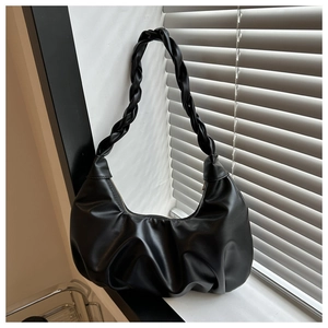 Detail of black matte PU leather hobo bag with pleated texture and braided shoulder strap