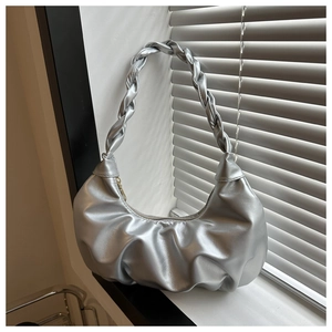Detail view of metallic silver hobo bag with pleated texture and braided handle