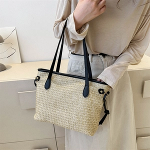 Grande borsa tote in paglia alla moda con manici in pelle nera su modella