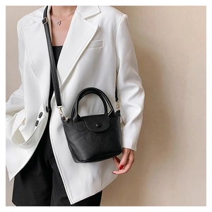 Close-up of black lychee texture PU leather mini bucket bag with snap closure and strap