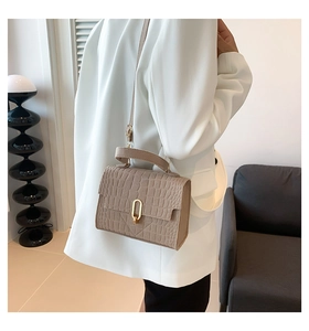Detail of khaki embossed faux crocodile pattern on a retro luxury shoulder bag with gold lock