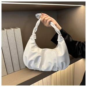 Close-up of white pleated dumpling bag with soft PU leather and knotted handle design