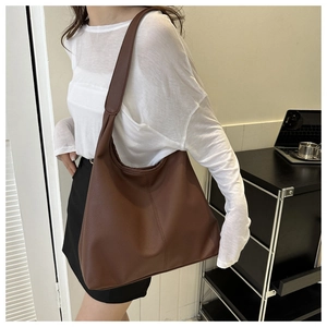 Deep brown large capacity PU leather tote bag shown on model in modern room