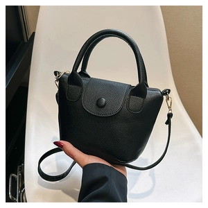 Detailed close-up of a black lychee texture PU leather mini bucket bag with gold hardware