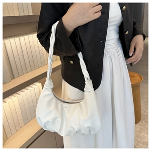 Close-up of white pleated cloud hobo bag featuring a woven shoulder strap and metal zipper