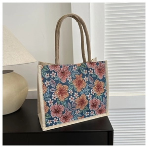 Detail of tropical floral linen tote bag with cream braided rope handles and woven texture