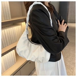 Detailed side view of white pleated cloud bag with a chunky braided shoulder strap