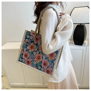 Close-up of a floral linen tote bag with vibrant orange and pink hibiscus patterns