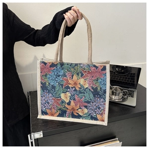 Detail of floral jacquard pattern and sturdy woven handles on a tote bag