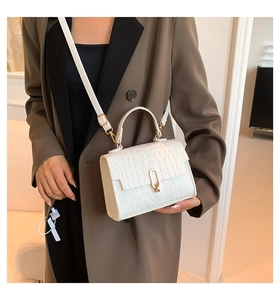 Detailed view of white crocodile pattern crossbody bag with elegant golden U-shaped buckle