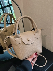 Khaki pebbled faux leather bucket bag with top handles and a detachable shoulder strap