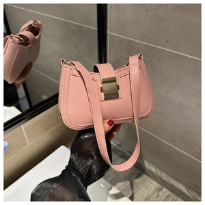Dettaglio macro di una borsa hobo rosa in ecopelle con fibbia quadrata in metallo dorato