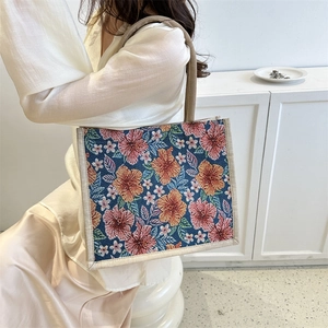 Linen tote bag with vibrant hibiscus floral prints and sturdy rope handles on white background