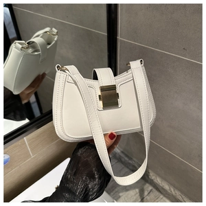 Dettaglio della borsa a spalla in ecopelle bianca con cuciture verticali e fibbia dorata
