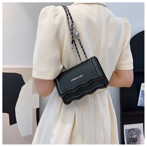Fashionable black wave texture crossbody bag with silver chain strap shown on a model