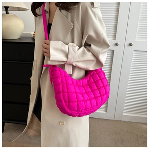 Detail of fuchsia quilted crescent shoulder bag with puffy bubble texture for women